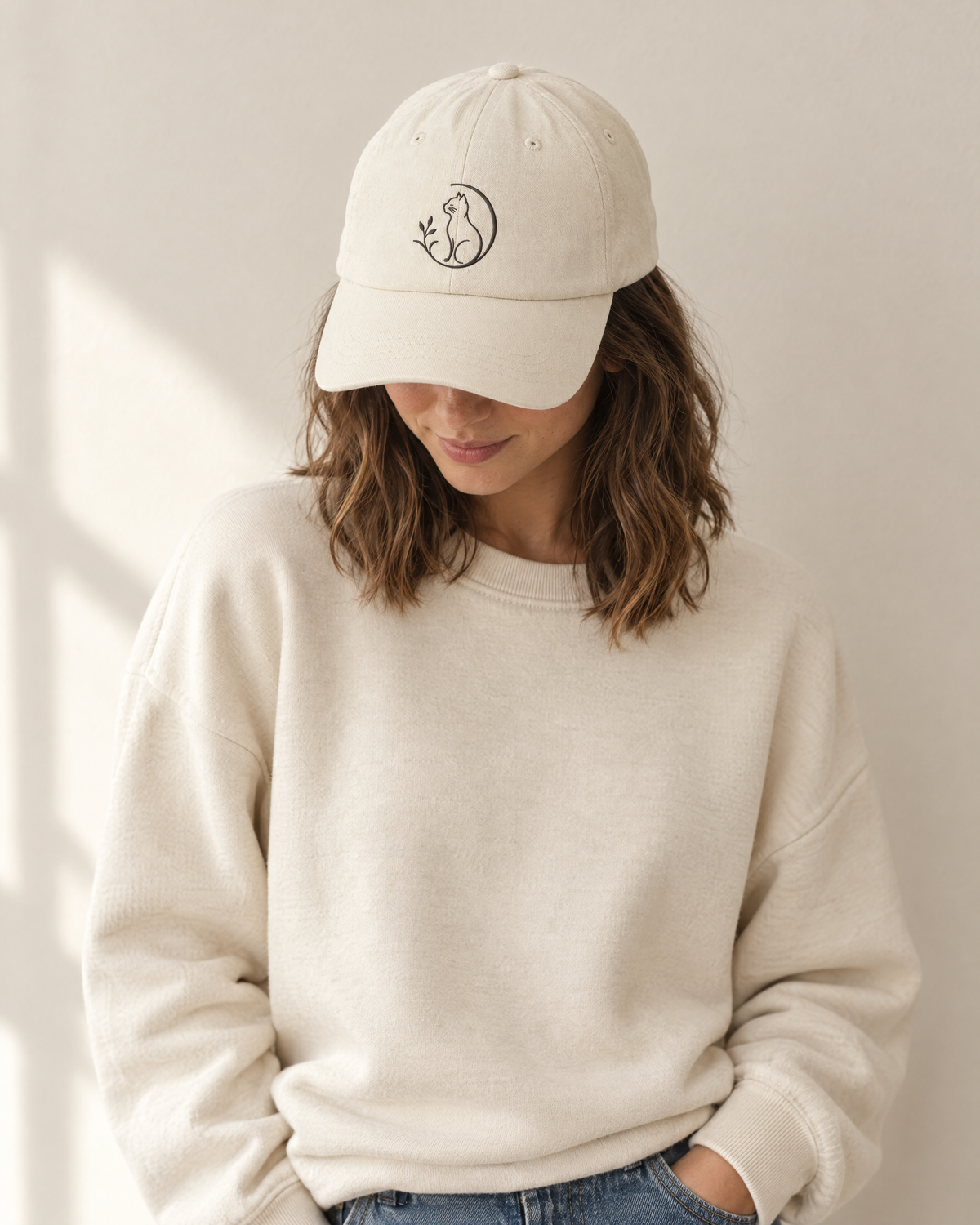 Frau trägt die beige Mr. Fluffel Cap mit gesticktem Katzen-Logo