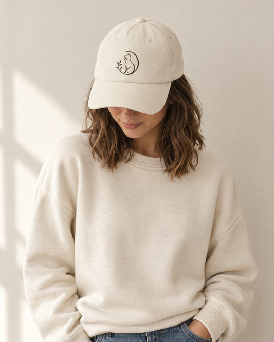 Frau trägt die beige Mr. Fluffel Cap mit gesticktem Katzen-Logo